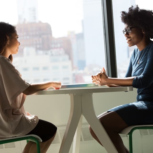 Deux personnes en conversation autour d'une table